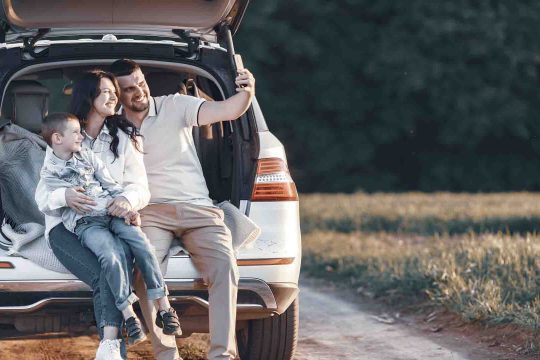 Family in a forest. People by the car. Sunset background.